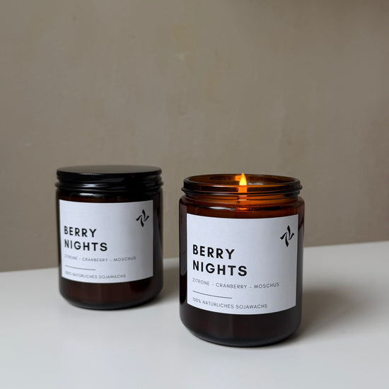 sevenlights Berry Nights scented soy candle in a brown glass jar with a lit cotton wick and minimalist label
