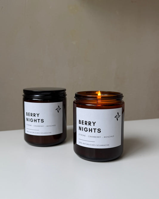sevenlights Berry Nights scented soy candle in a brown glass jar with a lit cotton wick and minimalist label
